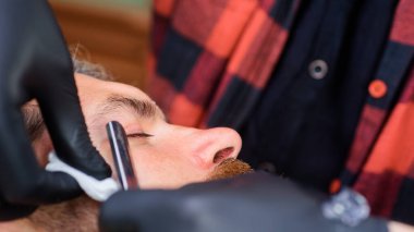 Sakallı adam. Profesyonel sakal bakımı. Berber dükkanındaki sakallı adam. Berber dükkanında müşteriye hizmet eden kuaför. Düz tıraş bıçağı, berber dükkanı. Klasik berber dükkanı, tıraş. Erkek kuaför. Yakın plan portre