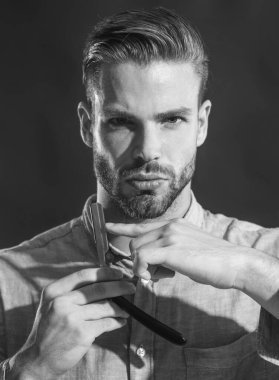 Berber dükkanı. Klasik berber aletleri. Sakallı adam, sakallı erkek. Tıraşsız şık bir adam keskin bir jilet gösteriyor. Berber dükkanı, kuaför, tıraş sakalı. Düz tıraş bıçağı, berber. Siyah ve beyaz