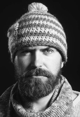 Erkekler için şık, sıcak tutacak kıyafetler. Sakallı, bıyıklı, yün atkı ve şapkalı çekici bir adamın portresi. Mükemmel bir tarz. Sonbahar ya da kış kıyafetleri giymiş ciddi sakallı bir adam. Siyah ve beyaz