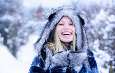 Kareli ceketli, kürklü ve eldivenli, kış parkında yürüyen gülümseyen kızın yakın plan portresi. Kış ormanlarında örnek bir kız. Karlı kış gününde, kalın giysiler içinde güzel bir Noel kadını.