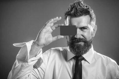 İş adamı, finansör ya da kredi kartı, banka kartı ya da ödeme kartı olan bir bankacı. Çevrimiçi alışveriş, para, finans, nakit ödeme. Banka servisi. Boş kartviziti olan gülümseyen sakallı adam. Siyah ve beyaz