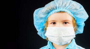 Tıbbi maskeli çocuğun yakın plan portresi. Salgın hastalık, salgın hastalık, virüs ya da enfeksiyondan korunma. Koruyucu maskeli şirin çocuk. Tıbbi maske takan küçük bir çocuk. Reklam için boşluk kopyala