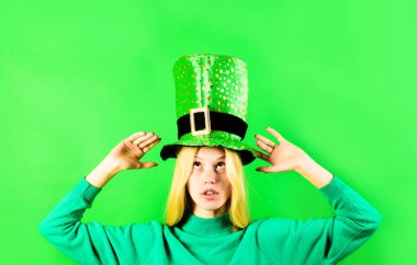 Patrick's Day girl. Young woman in green top hat. Patrick's Day leprechaun model girl in green hat with shamrock leaves. Cute girl in leprechaun hat for Patrick's Day. Traditions of Saint Patrick Day clipart