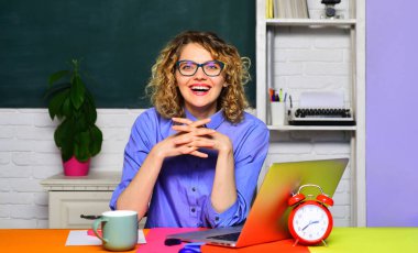 Öğretmen ya da üniversite profesörü sınıfta masa başında kahve molası veriyor. İş yerinde elinde bir fincan çayla gülümseyen öğretmen. Sınav ya da sınav için gözlüklü bayan öğrenci. Öğretmen dizüstü bilgisayarla çalışıyor