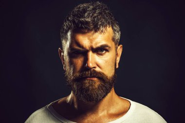 Erkek portresi. Güzel saç stili olan yakışıklı sakallı adam. Sakallı ve bıyıklı, rahat giyimli, kendine güveni tam bir adam. Acımasız sakallı adamın yakın plan portresi. Beyaz kazaklı, modacı erkek.