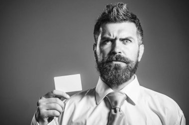 Ciddi sakallı adam boş kartvizit gösteriyor. Kredi kartı, banka hesabı ya da ödeme kartı olan bir bankacı ya da işadamı. Çevrimiçi alışveriş, para, finans, nakit ödeme. Reklam bankacılığı hizmeti için boşluk kopyala