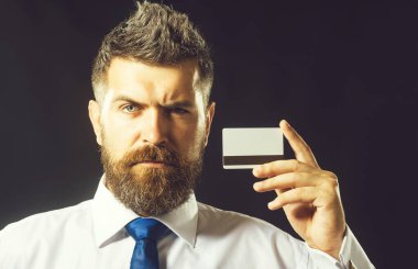 Kredi kartı, banka kartı ya da ödeme kartı olan ciddi sakallı bir adam. Çevrimiçi alışveriş, para, finans, nakit ödeme. Banka ya da iş adamı manyetik çizgili banka kartı gösteriyor. Bankacılık reklamı