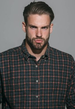 Erkek portresi. Kareli gömlekli ciddi tıraşsız bir adamın yakın plan portresi. Ekose gömlekli, şık saç stili olan seksi erkek model. Sıradan kıyafetler içindeki yakışıklı sakallı adam. Sakallı, şık bir adam.