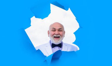 Takım elbiseli mutlu sakallı adam kağıttaki delikten bakıyor. Takım elbiseli ve papyonlu bir iş adamı mavi kağıtta delik açar. Gülümseyen yaşlı kel adam kağıt deliğinden bakıyor. İndirim, satış, sezon satışları