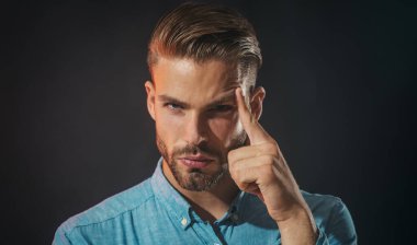 Düşünen adam. Kot gömlekli genç adam bir şey düşünüyor. Gündelik giysiler içindeki endişeli bir adamın yakın plan portresi. Sorular için endişelenen düşünceli bir adam. Düşünceli ifade