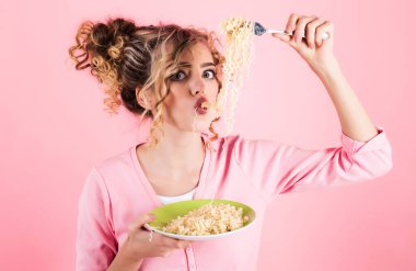 Erişte yiyen güzel bir kız. Lezzetli İtalyan spagettisi yiyen bir kadın. Kıvırcık saçlı moda kadın çatallı İtalyan makarnası yiyor. Bir tabak hazır şehriyeli seksi kız. Sabah kahvaltısı