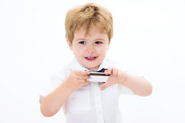 Kredi kartıyla. Kredi kartı ya da banka kartı ile gülümseyen çocuk. Küçük çocuk, manyetik şeritli bir şablon gösteriyor. Ödeme işlemi, e-para, finansal başarı. Bankacılık reklamı