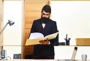 Ofiste çalışan bir işadamı elinde dosyayla masanın başında duruyor. Ofisinde açık not defteri olan takım elbiseli sakallı bir adam. Kendine güvenen bir iş adamı mali raporları okuyor. Başarılı bir iş.