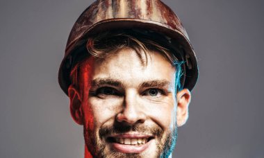 İnşaatçı adam. Koruyucu kasklı erkek müteahhidin yakın plan portresi. İnşaat endüstrisi ve inşaat. Kasketli yakışıklı adam. Gülen mühendis, mimar ya da sanayi işçisi.