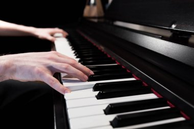 Person playing the piano musical instrument. Close up of a keyboard player's hands. Black and white keys