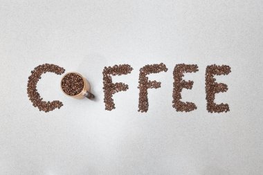 Coffee text word made from beans written on white kitchen counter background. Idea and message concept