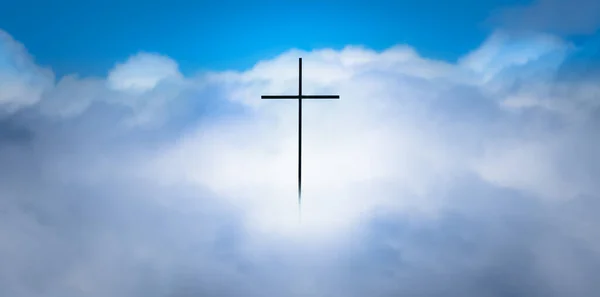 Christian cross silhouette in heavenly clouds background. Resurrection of Jesus Christ for the forgiveness of sins faith concept. Crucifix floating in white puffy clouds