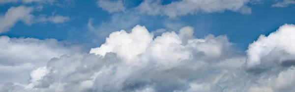 Beautiful white puffy clouds and blue sky panoramic background. Heavenly cloudscape banner