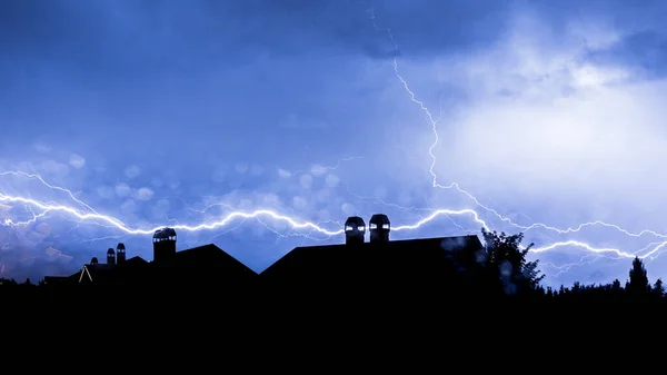 House chimney lightning bolt strike during thunder storm extreme weather background. Silhouette of home and rooftop hit by lightning