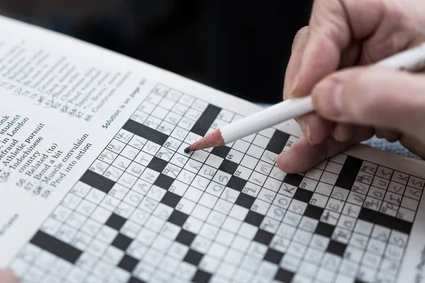 Das Lösen Eines Kreuzworträtsels Der Zeitung Aus Nächster Nähe Abschließen — Stockfoto