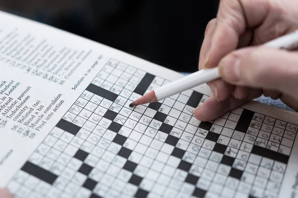 Solving Crossword Puzzle Newspaper Close Hand Background Completing Fun Puzzle Stock Picture