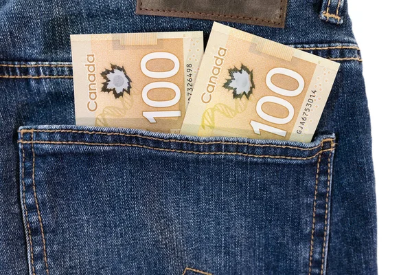 Money in pocket. Canadian money currency one hundred dollar paper bills in a jeans pocket. Saving and spending concept