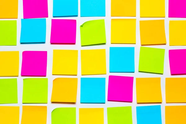 Colorful blank sticky notes on white wall isolated background. Reminder and business office supplies stationery wallpaper