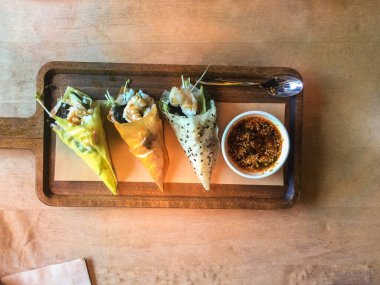Ahşap bir tabakta lezzetli suşi külahı aperatifi. Japon usulü deniz ürünleri koni restoranı hizmeti.