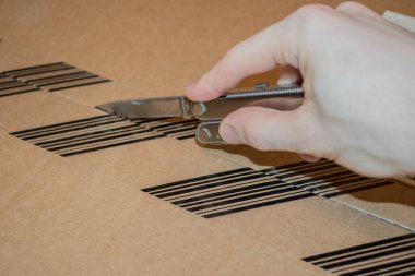 Keskin bir bıçakla karton kutuyu açıyorum. Çevrimiçi alışveriş ve ulaşım kavramı