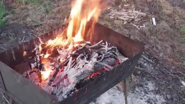 Köy manzarasında bir barbeküde odun yakmak.