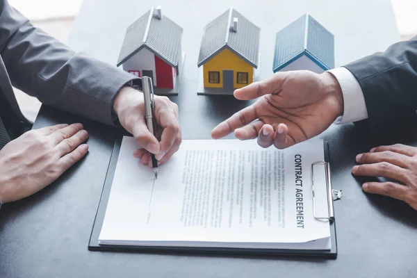 Home sales,home rental and real estate concept.Customer sign the document after real estate agent explain about the terms of the home purchase or rental agreement