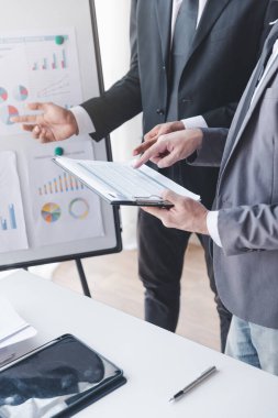 Finans ve yatırım konsepti, İşadamı iş finans yatırım planını ortağı, yatırımcı meslektaşlarıyla ofis masasında mali grafik verilerine göre yeni yatırım planını tartışırken sunar