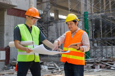 İnşaat alanında inşaat modeli ve planıyla çalışan mühendis ve mimar konsepti, inşaat alanında inşaat planını tartışan mühendis ve mimar