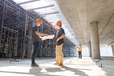 İnşaat alanında inşaat modeli ve planıyla çalışan mühendis ve mimar konsepti, inşaat alanında inşaat planını tartışan mühendis ve mimar