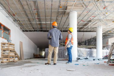 İnşaat alanında inşaat modeli ve planıyla çalışan mühendis ve mimar konsepti, inşaat alanında inşaat planını tartışan mühendis ve mimar