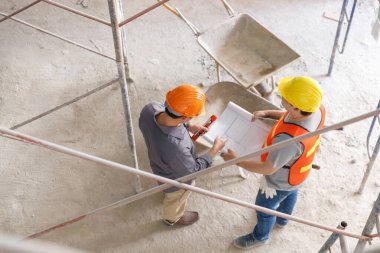 İnşaat alanında inşaat modeli ve planıyla çalışan mühendis ve mimar konsepti, inşaat alanında inşaat planını tartışan mühendis ve mimar