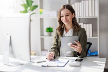 Concept of business investment or working woman,  Businesswoman wearing a suit sitting and working on analysis of business investment documents and using computer to analytic business data.