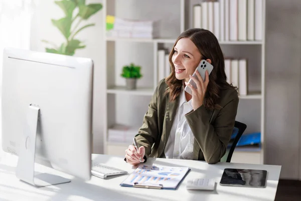 stock image Concept of business investment or working woman,  Businesswoman wearing a suit sitting and working on analysis of business investment documents and using computer to analytic business data.