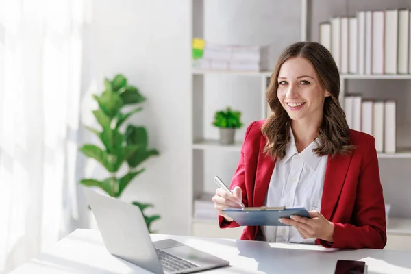 Concept of business investment or working woman,  Businesswoman wearing a suit sitting and working on analysis of business investment documents and using computer to analytic business data.
