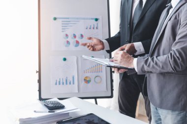 Finans ve yatırım konsepti, İşadamı iş finans yatırım planını ortağı, yatırımcı meslektaşlarıyla ofis masasında mali grafik verilerine göre yeni yatırım planını tartışırken sunar