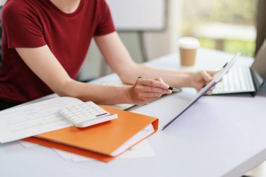 İş kadını çalışma kavramı, yakın plan iş kadını hesap makinesi ve dizüstü bilgisayar kullanarak belge ve iş yatırımı grafik verilerini analiz ederek yatırım planını kontrol ediyor