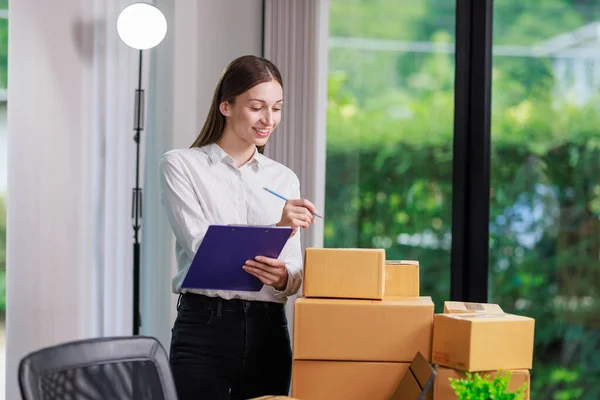 stock image Concept of parcel delivery and selling online,Retailer writing customer detail on parcel box and prepare to send product parcel to the customer