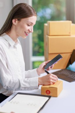 Paket teslimatı ve çevrimiçi satış kavramı, paket kutusuna müşteri ayrıntıları yazma ve ürün paketini müşteriye göndermeye hazırlan