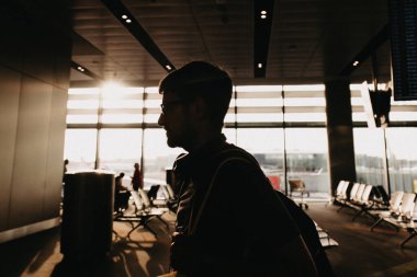 Silhouette of man walking through airport terminal