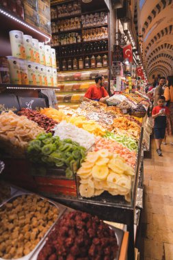 İstanbul, Türkiye - Ekim 12022: Türkiye 'nin İstanbul kentindeki ünlü pazarda renkli bir şekerleme, Türk Lokumu ve kurutulmuş meyve sergisinde müşteriler ve satıcılar.