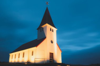 Geceleyin aydınlanmış Reyniskyrka Kilisesi 'nin akşam görüntüsü, İzlanda' nın güneyindeki Vik kıyı köyünde pitoresk bir şapel..