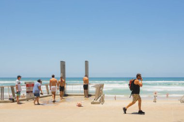 Surfers Paradise, Avustralya - 4 Ocak 2023: Sörfçüler ve ziyaretçiler güneşli bir yaz gününde Sörfçüler Cenneti, Queensland, Avustralya 'da halk plajı sağanağı kullanıyorlar.
