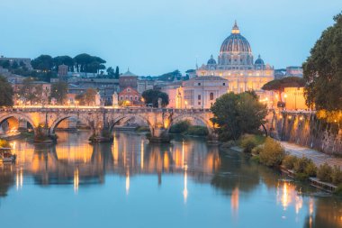 Vatikan 'daki Aziz Peter Bazilikası ve Tiber Nehri boyunca uzanan Ponte Vittorio Emanuele II' nin alacakaranlık manzarası bir yaz akşamı İtalya 'nın başkenti Roma' da aydınlandı..