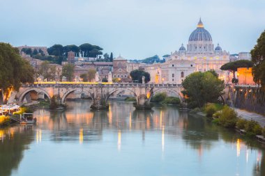 Vatikan 'daki Aziz Peter Bazilikası ve Tiber Nehri boyunca uzanan Ponte Vittorio Emanuele II' nin alacakaranlık manzarası bir yaz akşamı İtalya 'nın başkenti Roma' da aydınlandı..