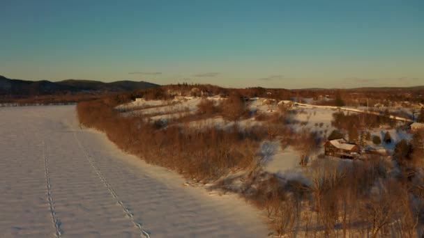 風光明媚な冬の夕日の間に小さな町をカバー雪の絵の空中ビュー — ストック動画